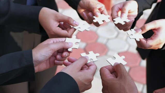 we are compatible A group of businessmen is working on puzzles together.
