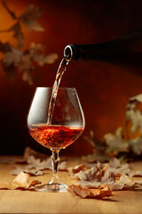 Cognac is poured into a glass from a bottle.