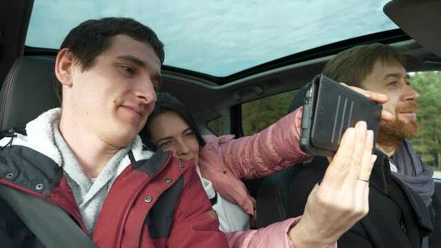 Woman and Man Take Selfie Photo Picture Smartphone Phone. Friends Travel Together by Car. Group of Tourists Journey Family Trip. SUV Panoramic Glass Roof. Winter Attire Autumn. 2x Slow motion 60 fps 4