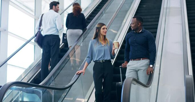 Back to work after break time. 4k video footage of two young businesspeople coming down the escalator at work.