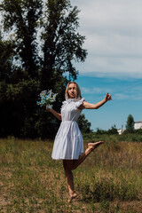 The girl holds flowers in her hand and jumps with happiness