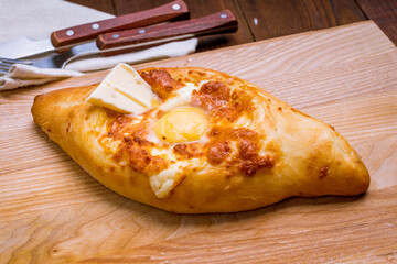 ajara Khachapuri with cheese, egg and butter, georgian kitchen on wooden table