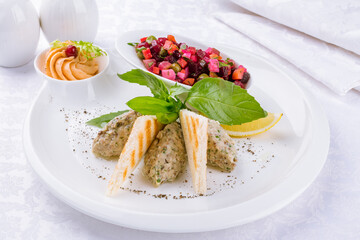 forshmak of herring with croutons and vinigret on a white plate