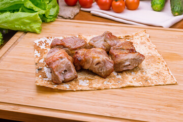Kebab of pork on the board macro close up