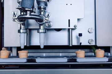 Manufacturin for automatic production of ice cream cones. Conveyor belt in waffle cups, creme brulee. Sweets modern factory. Food dairy industry, automated technology equipment and engineering concept