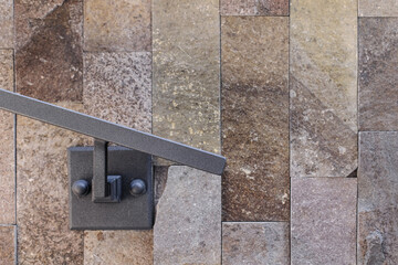 Fastening a metal handrail to the stone wall near the house. Fastening of a metal fence and a grid. handmade. high quality photo.