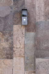 External video intercom with a speaker mounted on the stone column of the gate of the mansion of...