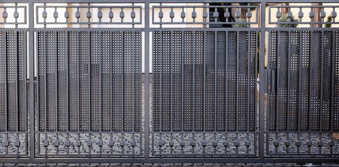 Modern anthracite panel fence, visible sliding gate to the garage, view from the garden.