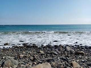 Playa con piedras y rocas con oleaje