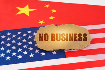 On the flags of the USA and China lies a cardboard sign with the inscription - No Business