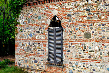 finestra diroccata su facciata in pietra e mattoni