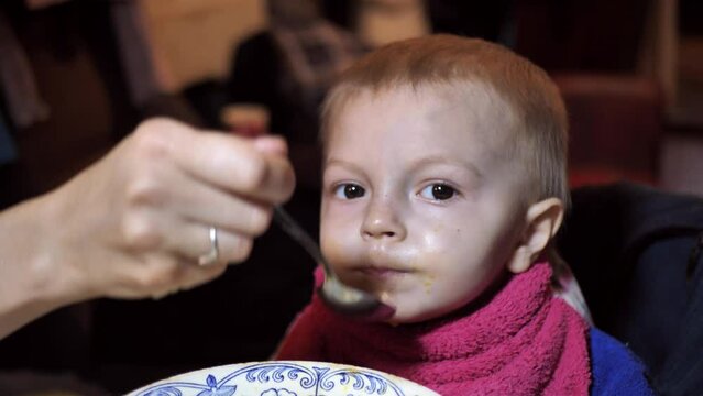 Mother Feeds The Child.Close-up Of A Small Child .social Inequality, Poverty