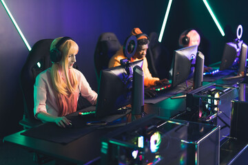 Fototapeta na wymiar Interracial Team Playing Esports Games on Computers Using Professional Equipment. Gaming Cafe Interior. High quality photo