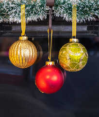 red and gold Christmas decorations hanging from gold ribbon