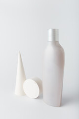 white care cosmetics bottle, shampoo or hair conditioner with concrete decorative elements. monochrome geometrical composition