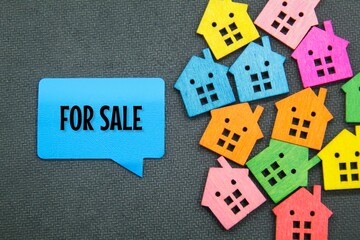 small colored houses and conversation boxes with the words For Sale. concept of real estate for sale