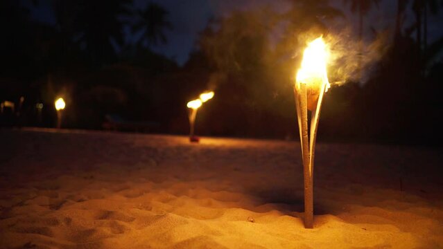 4K Torches alight on beach during New Years night in Zanzibar. Authentic lifestyle, celebrations, festivities concept.