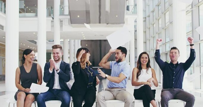 Well done guys and girls for making it this far. 4k video footage of a group of cheerful young businesspeople seated next to each other while waiting for interviews in the office.
