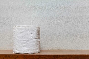New rolls of tissue paper on a wooden shelf in the bathroom