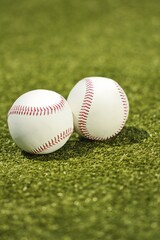 Two baseballs on neatly mowed grass