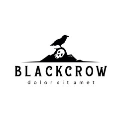 Vector logo in which an abstract a black crow raven stands on a skull