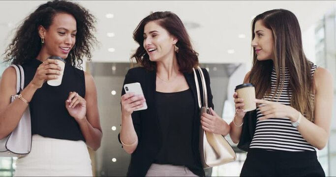 When a business network becomes a friendship. 4k video footage of young businesswomen chatting and using a smartphone while walking in an office on a coffee break.