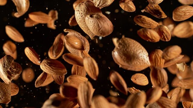 Super Slow Motion Shot of Flying Whole Almonds and Nut Shells Towards Camera on Black at 1000fps.