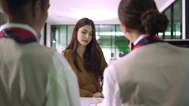 Passengers or travellers are checking in at the airport to load their luggage and pick up their tickets or boarding passes at international airport in travel and transportation concept.