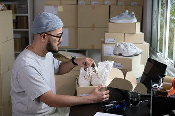 Asian man business owner working, packing the order for shipping to customer. Male entrepreneur...