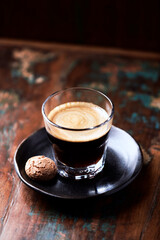 Coffee in glass cup on rustic wooden background