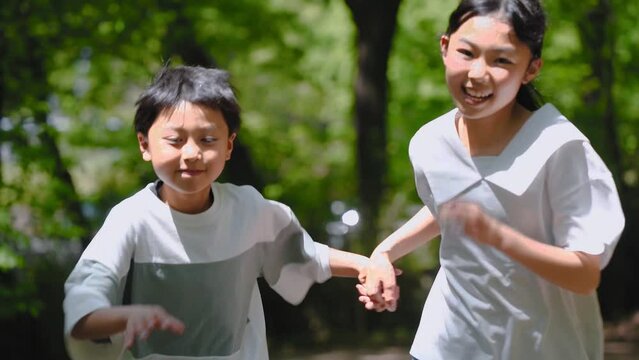 自然の中を笑顔で走るアジア人の子供