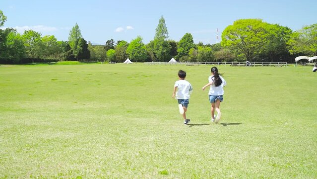 自然豊かな公園を走るアジア人の子供