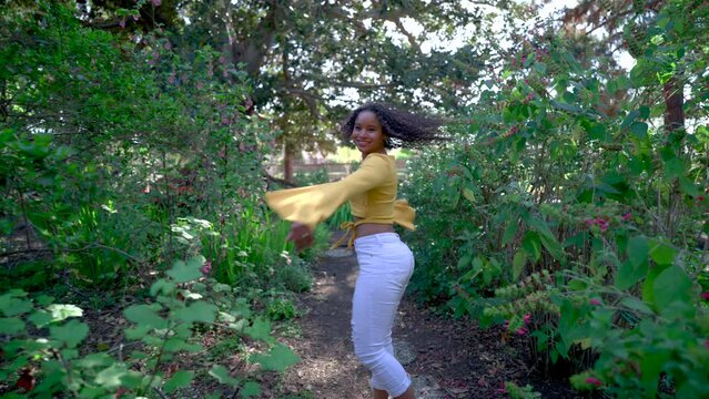 Young woman running through a garden