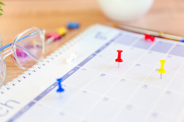 Calendar, Close-up red pin on blank desk calendar with office equipment concept of event planner or personal organization for business and appointment reminder and schedule planning.