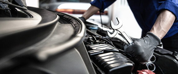 Car care maintenance and servicing, Close-up hand technician auto mechanic using the wrench to...