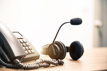 Customer service concept. Close-up headphone and telephone for communication helpdesk IT support or call center and online services.