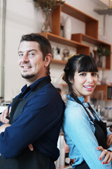 Smiling Caucasian Young barista couple love or partnership is wearing apron and happy for working in the coffee shop. Start up for small cafe business owner concept.