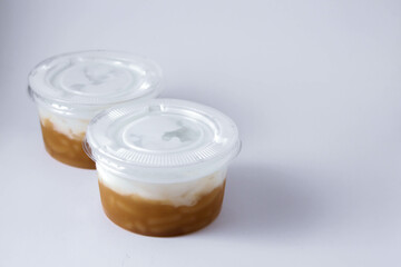 Sweet Rice Noodles with Coconut Cream in a plastic cup on a white table.