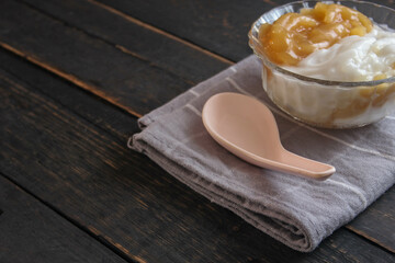 Sweet Rice Noodles with Coconut Cream served in a glass cup on a black wooden table.
