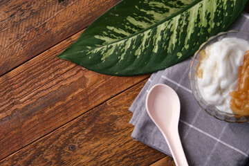 Sweet Rice Noodles with Coconut Cream served in a glass cup on a brown wooden table.