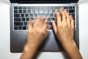 Hand typing a laptop keyboard