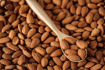 Almonds in wood bowl on wood table.Diet raw material