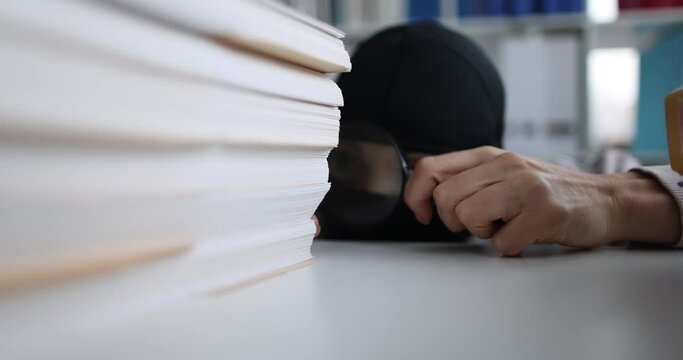 Scammer examines business documents of competitor in office