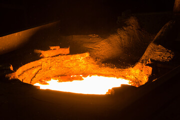 Closeup of glowing hot liqud metal in furnace