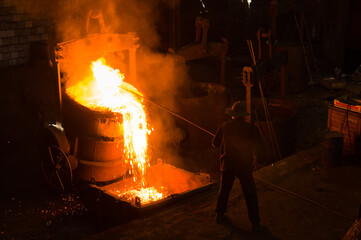 Metallurgist removing slack from hot molten metal