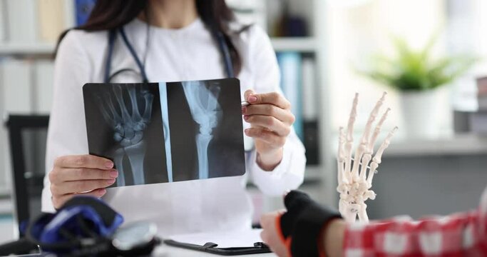 Traumatologist examines x-ray of patient hand