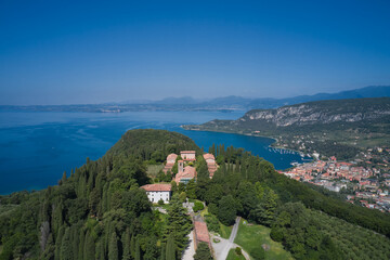 Fototapeta na wymiar Monastery on the Eremo di San Giorgio hill,.Lake Garda, Italy. Aerial view of Eremo di San Giorgio, Bardolino. Aerial panorama Monastery on the hill. Home of Italian monks, lake garda.