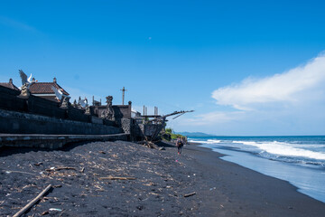 Tropical unusual exotic beach with black volcanic sand, blue sky with clouds. Nobody. Kusamba beach, Bali, Indonesia
