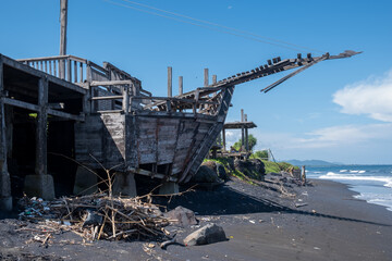 Tropical unusual exotic beach with black volcanic sand, blue sky with clouds. Nobody. Kusamba beach, Bali, Indonesia