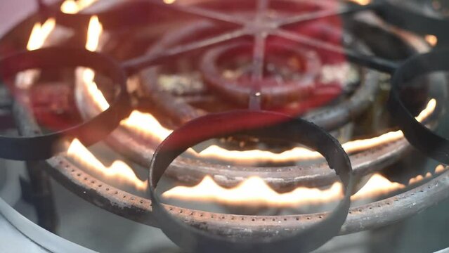 Close up of burning stove for cooking national Arabic knafeh sweets. Over fire rotates round hoops for plates. Such device allows quickly prepare delicious dish.